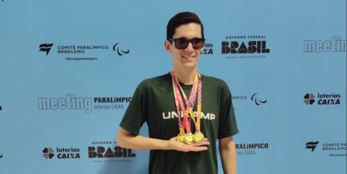 Foto de Amauri Leal Jr., doutorando da FCF, segurando suas três medalhas de ouro