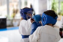 Girl and boy having fight while wearing protective gloves and helmets